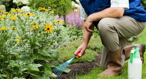 Worker using protective equipment while handling garden waste and tools